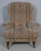 A 19th century style armchair in tapestry upholstery on turned tapering supports. H.100 W.83 D.70cm