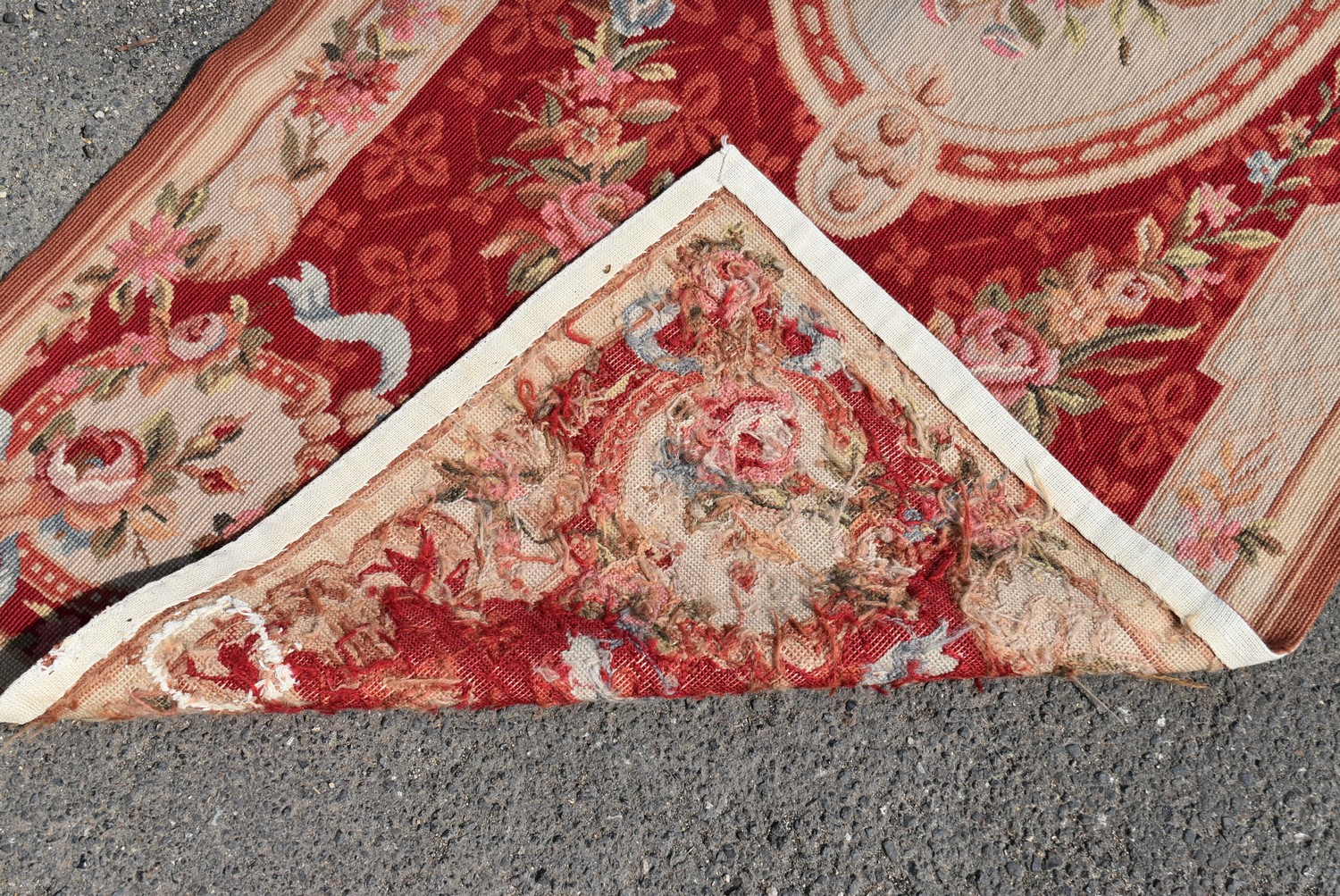 A needlepoint rug with central floral cartouche on a burgundy field within ribbon and flowerhead - Image 4 of 4