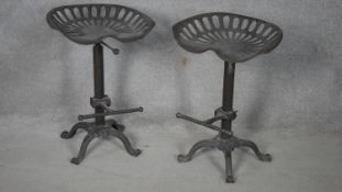 A pair of 19th century style cast iron industrial stools on quadruped supports with footrests. H.