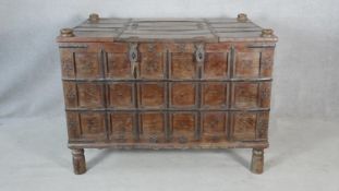 An Eastern metal bound and studded hardwood panelled coffer raised on circular section supports. H.
