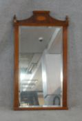 An Adam style yew framed wall mirror with inlaid patera and urn finials to the cresting and bevelled