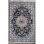 A Persian silk & wool Naiin rug with central floral medallion on a midnight ground within floral