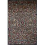 A needlepoint carpet with all over naturalistic flowerhead and leaf design within a wide floral