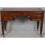 A 19th century mahogany kneehole writing table with inset tooled teather top raised on tapering