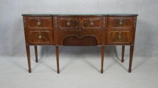 A Georgian style flame mahogany sideboard with an arrangement of cupboards and drawers on square