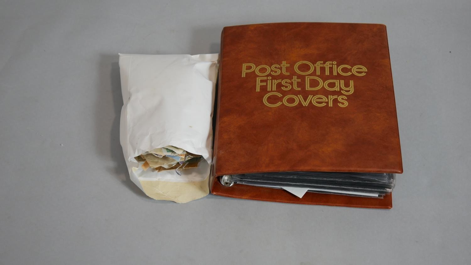 A large collection of loose world stamps and a Post Office leather effect binder of various first