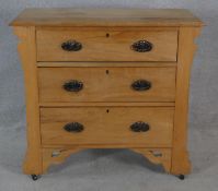 A late 19th century satin walnut chest of drawers with original Art Nouveau handles, carved frieze