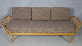 A mid century blonde elm and beech Ercol model 355 studio couch with surfboard back and original