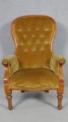 A Victorian beech framed armchair in buttoned upholstery on turned and tapering supports. H.103.5cm