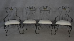 A set of four wrought metal conservatory dining chairs with cut floral upholstered seats on