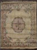 A large carpet with floral central medallion on a biscuit ground within foliate spandrels and
