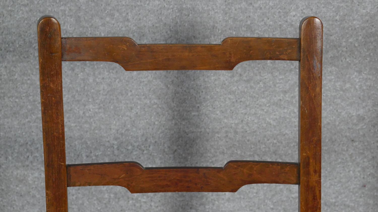 A pair of C.1900 oak ladderback chairs with woven rush seats on circular stretchered supports. H. - Image 5 of 5