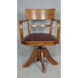 A mid century vintage teak swivel office desk chair with maker's plaques to the underside. H.83cm