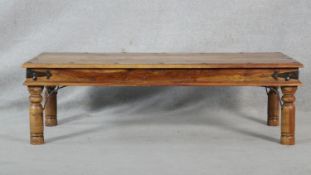 An Indian hardwood metal bound and studded low table on circular section supports. H.41 L.136 W.61.