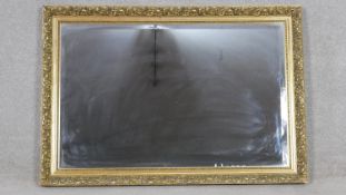 A contemporary bevelled glass wall mirror in floral gilt and beaded frame. H.67 W.97.5cm