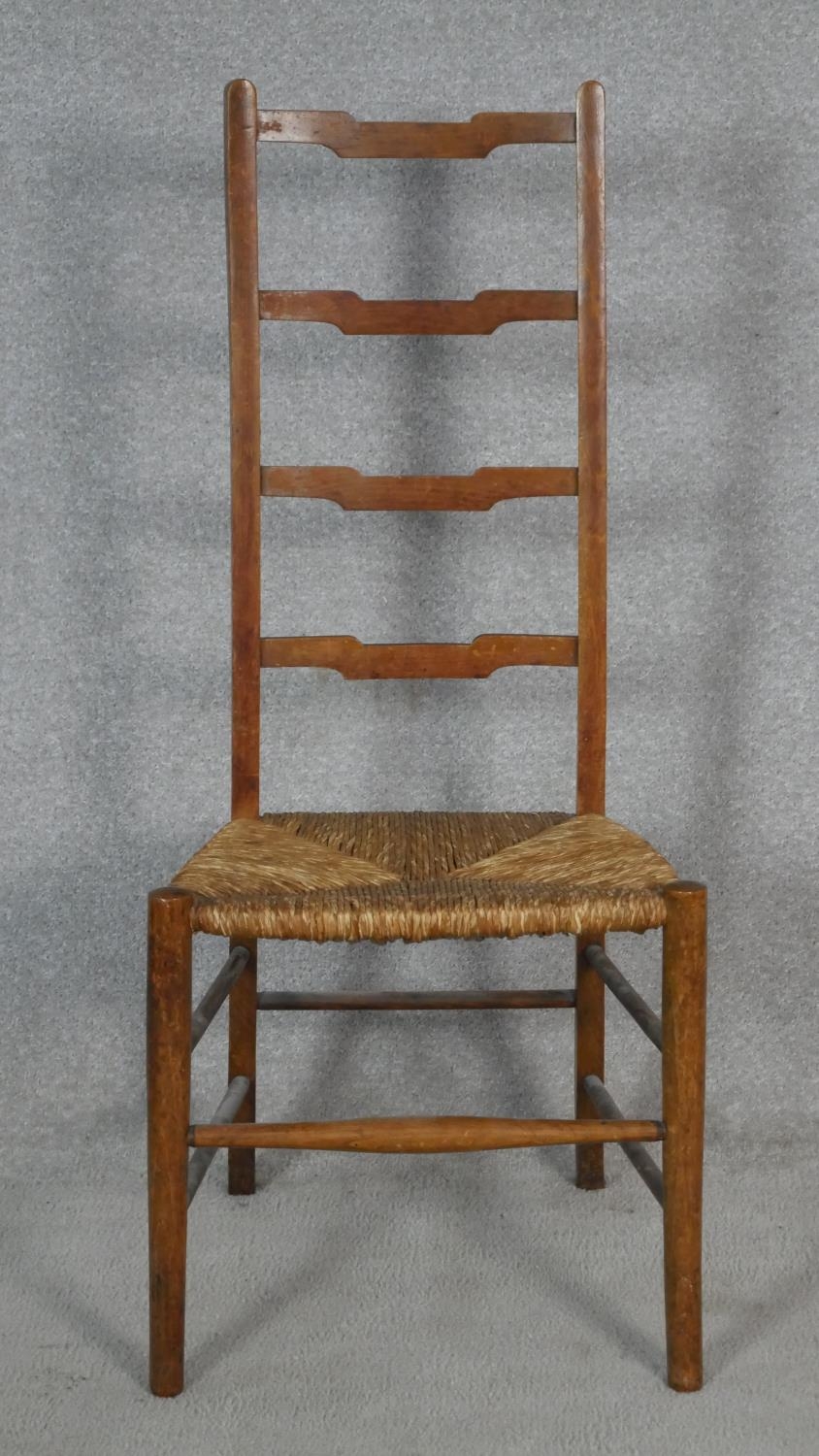 A pair of C.1900 oak ladderback chairs with woven rush seats on circular stretchered supports. H. - Image 2 of 5