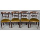 A set of four William IV mahogany bar back dining chairs with acanthus carved splats above stuff