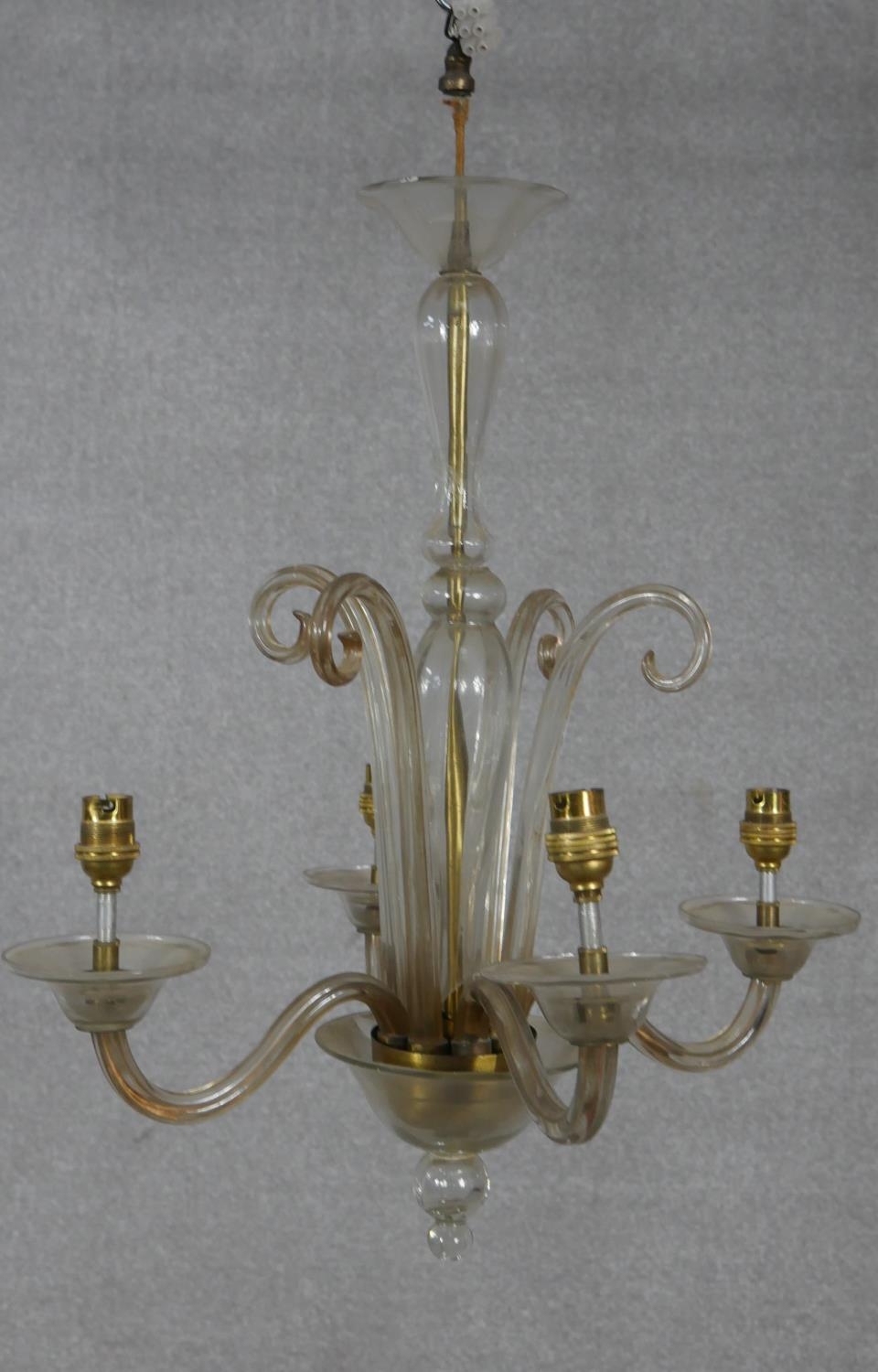 A Venetian style four branch glass chandelier with scrolling arms and finials. D.49cm (small break