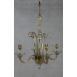 A Venetian style four branch glass chandelier with scrolling arms and finials. D.49cm (small break