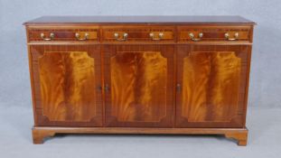 A Georgian style crossbanded and inlaid sideboard with inset figured mahogany panels. H.87 W.151 D.