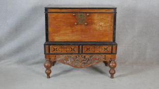 A Nineteenth Century Ceylonese hardwood and ebonised coffer on carved stand fitted with two base