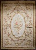 A hand made Aubusson carpet with central oval medallion with floral bouquet on a scrolling foliate
