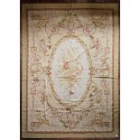 A hand made Aubusson carpet with central oval medallion with floral bouquet on a scrolling foliate