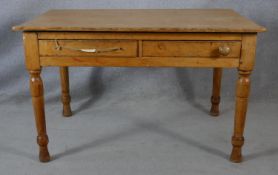 A Victorian pine two drawer side table on turned tapering supports. H.64.5 L.121 W.83cm