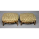 A pair of late 19th century carved giltwood footstools in tapestry upholstery on squat Rococo carved