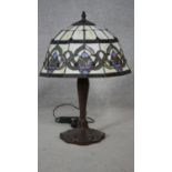 A Tiffany style table lamp with leaded coloured glass panels and tulip motifs to the base. H.55cm