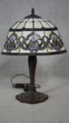 A Tiffany style table lamp with leaded coloured glass panels and tulip motifs to the base. H.55cm