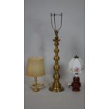 A tall brass table lamp base along with a smaller example with shade and a vintage brown glazed