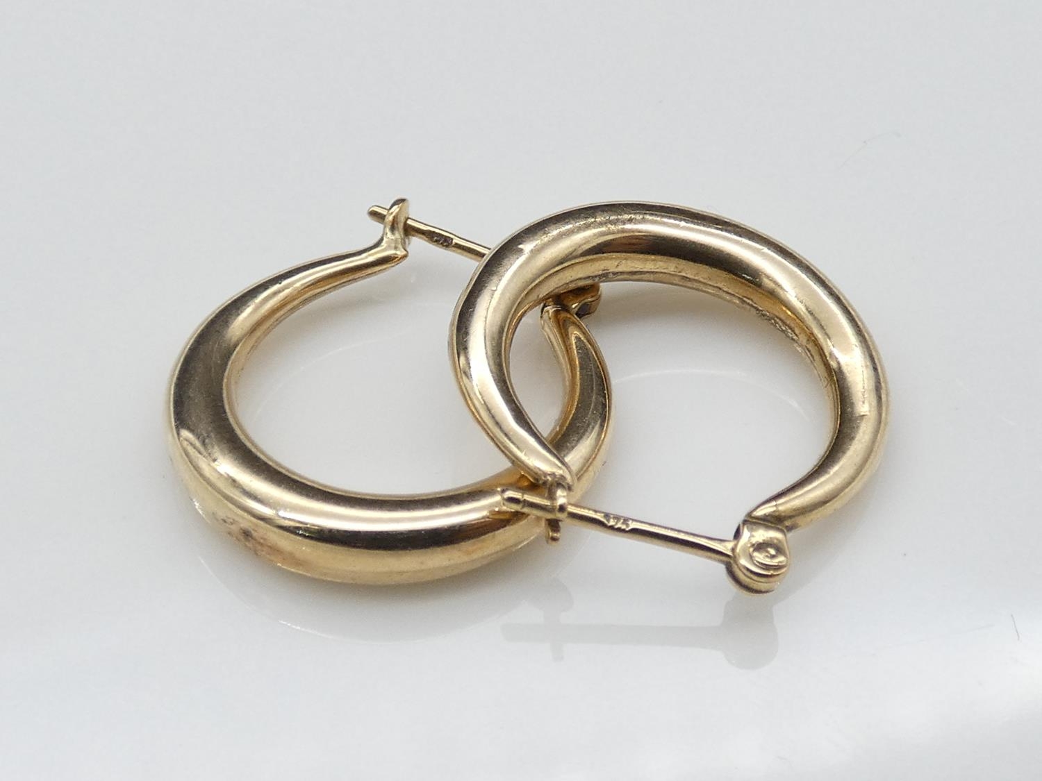 A pair of 9ct yellow gold hollow hoop earrings with secure bar fittings. Diameter 1.8cm.