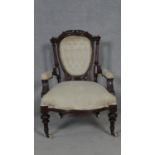 A Victorian buttoned back armchair in carved mahogany frame on fluted tapering supports. H.89cm