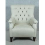 A contemporary tub armchair in buttoned and piped upholstery on tapering block supports. H.97 W.80