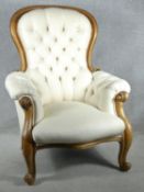 A Victorian carved beech framed armchair in deep buttoned upholstery on cabriole supports in fully