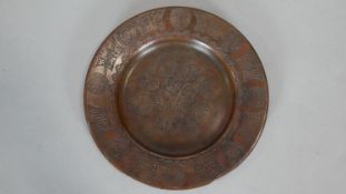 A copper Zand dynasty style plate impressed with various calligraphic motifs and stylised foliate