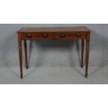 A 19th century mahogany writing table fitted with a pair of frieze drawers on ring turned tapering