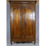 A 19th century French chestnut armoire with panel doors enclosing shelved interior above shell