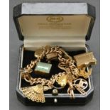 A vintage solid curb link 9ct gold charm bracelet with fifteen 9ct yellow gold charms. The charms