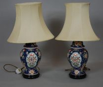 A pair of Chinese style baluster shaped table lamps painted with flowers and birds on circular