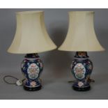 A pair of Chinese style baluster shaped table lamps painted with flowers and birds on circular