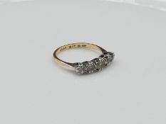 A 18 carat yellow gold and platinum five stone diamond ring. Central diamond weighs approximately