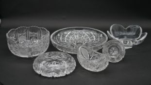 A collection of crystal items to include two cut crystal bowls, a boat shaped dish, two ash trays
