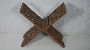 An Anglo-Indian carved pierced hardwood book stand. Decorated with dragons, foliage and flowers