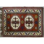 A Turkish Kars rug with double hooked medallions on a burgundy ground within stylised serrated