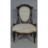 A Victorian buttoned back nursing chair in carved mahogany frame on fluted tapering supports. H.90cm