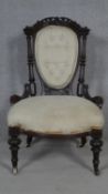 A Victorian buttoned back nursing chair in carved mahogany frame on fluted tapering supports. H.90cm