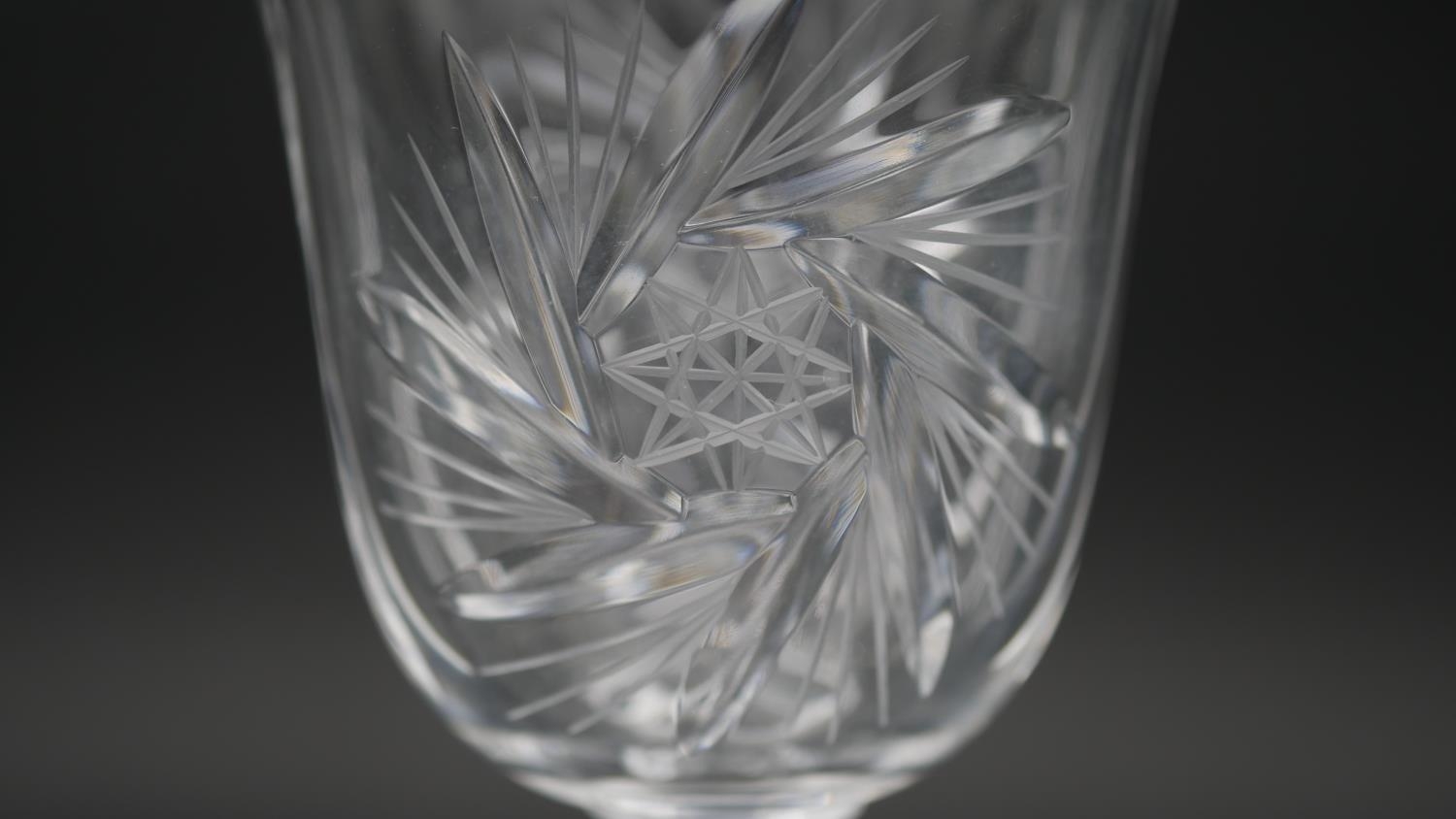 A set of eleven engraved and cut crystal wine glasses with star design and faceted stems. H.17.5cm - Image 4 of 4