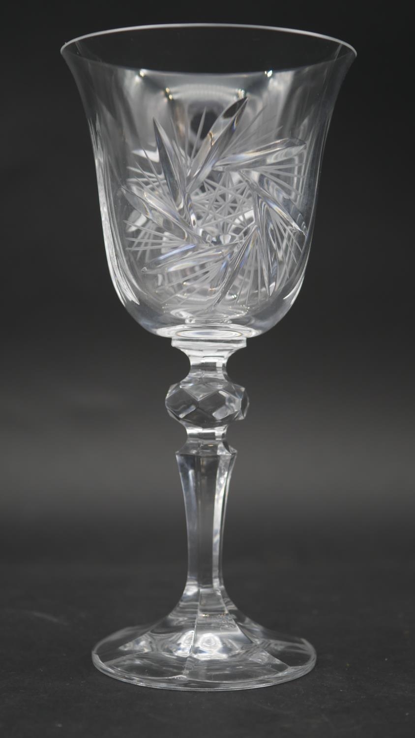 A set of eleven engraved and cut crystal wine glasses with star design and faceted stems. H.17.5cm - Image 2 of 4